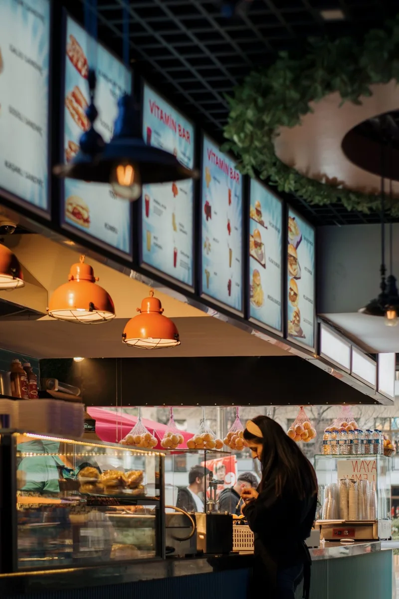 Illuminated menu displays above a real café counter